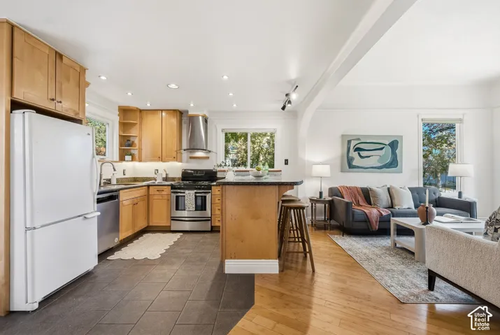 Kitchen with wood cabinetry, granite work surfaces with seating, and tile flooring