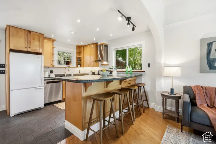 Kitchen with wood cabinetry, granite work surfaces with seating, and tile flooring