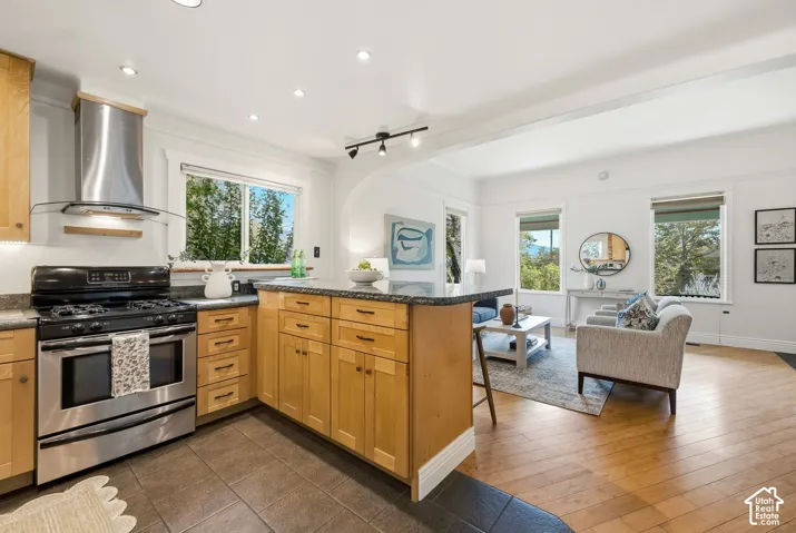 Kitchen with wood cabinetry, granite work surfaces with seating, and tile flooring