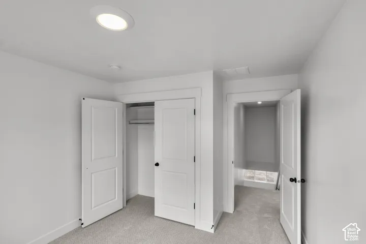 Recessed ceiling lighting, carpet flooring, flat-panel interior doors, and a closet with built-in shelving