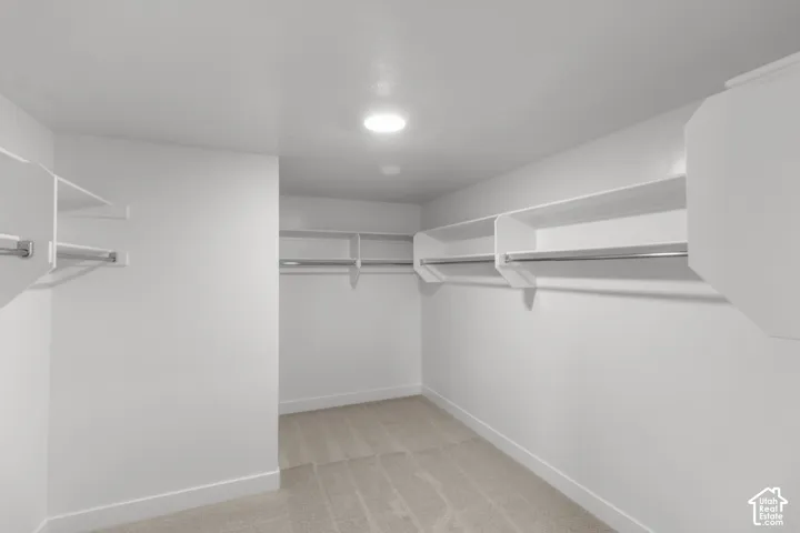 Walk-in closet featuring built-in shelving, chrome hanging rods, and recessed lighting