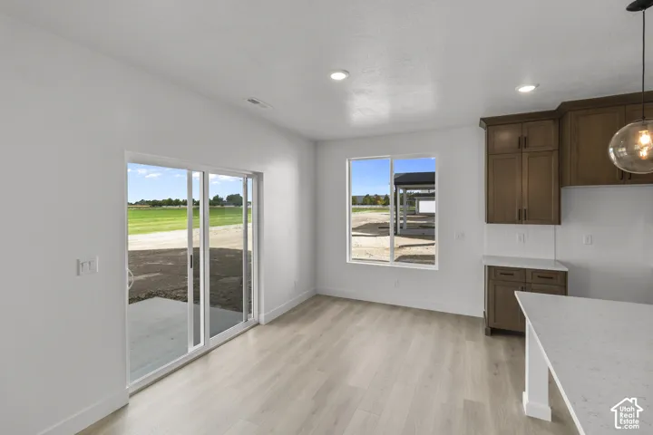 White walls, light-toned wood-finish flooring, and recessed lighting