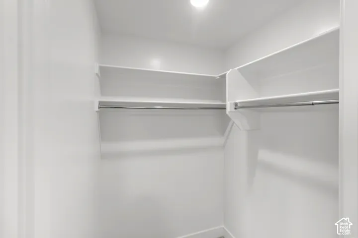 Walk-in closet with integrated shelving and chrome hanging rods