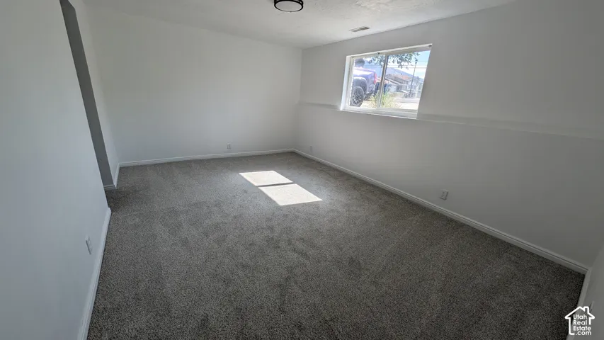 Recessed window, neutral wall paint, gray carpet flooring, ceiling-mounted light fixture