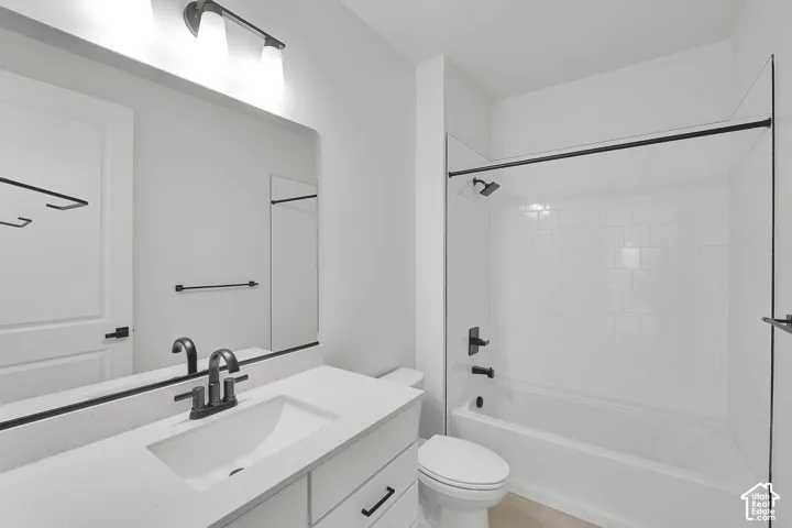 Bathroom featuring a white vanity with an integrated sink, quartz countertop, and black fixtures