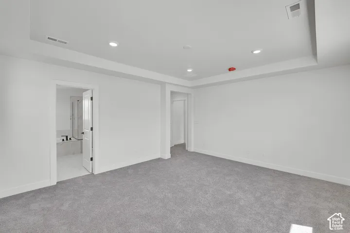Plush grey carpeting, recessed lighting, white walls, and white trim