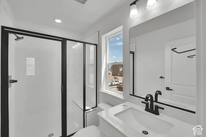 Shower with black-framed glass enclosure, white subway tile surround, and rainfall showerhead