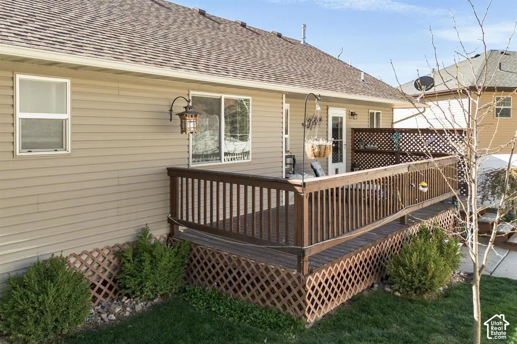 Exterior deck featuring wood railings, lattice skirting, and direct door access