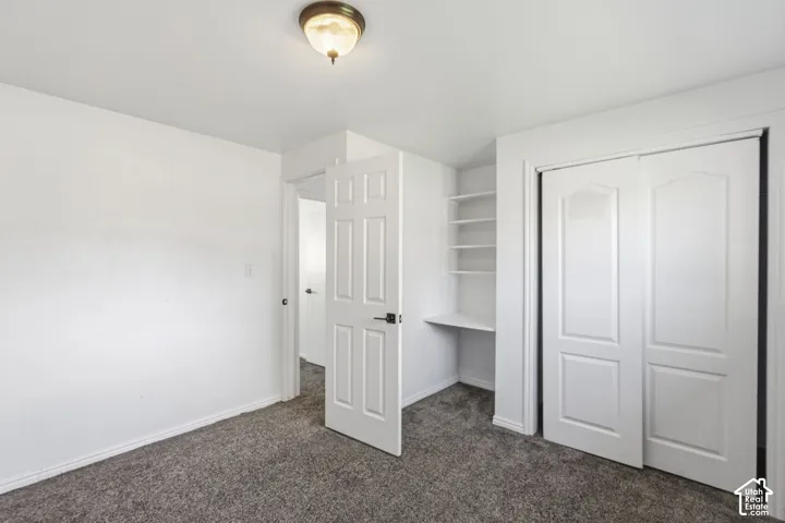 Neutral color palette with textured carpeting, built-in shelving, and a built-in desk