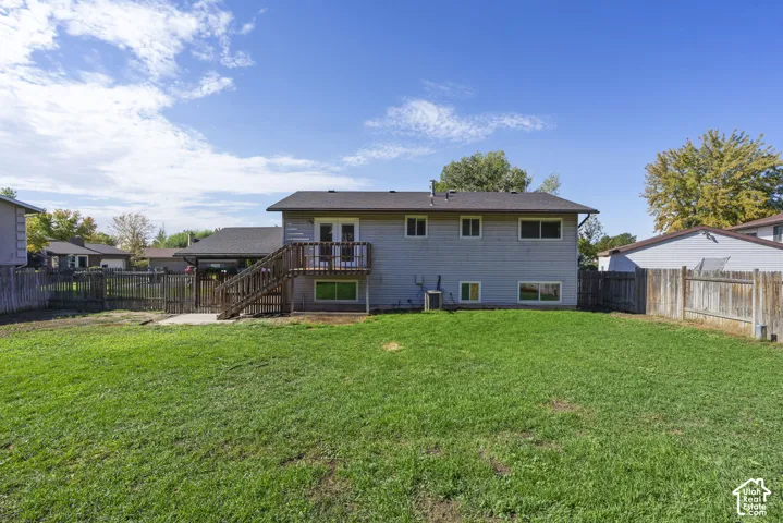 Expansive lawn with a wood fence perimeter and a raised wood deck