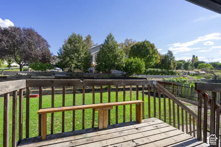 Wood deck with railing overlooking a lawn area