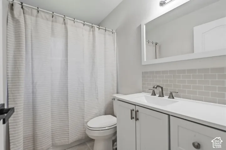 White vanity with dual cabinet doors and drawer, undermount sink, and dark-toned faucet