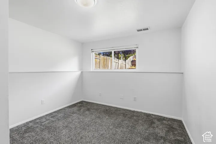 Interior space featuring a window, neutral wall paint, and gray carpet