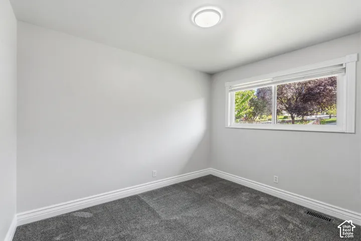 Recessed lighting fixture, gray carpet flooring, white trim, and a window with exterior scenery