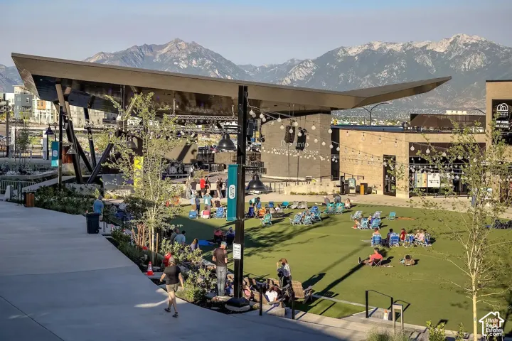 Spacious green lawn with a covered stage area and mountain backdrop
