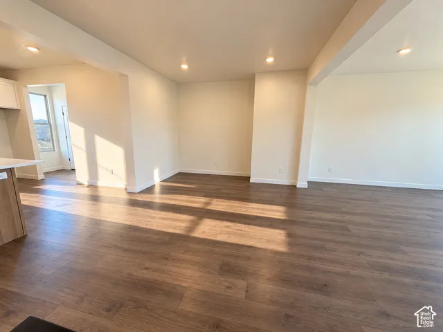 Spacious room featuring wood-finish flooring, recessed lighting, and light-toned walls