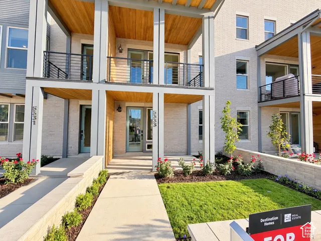 Modern facade featuring light-colored brick and wood-finish soffits