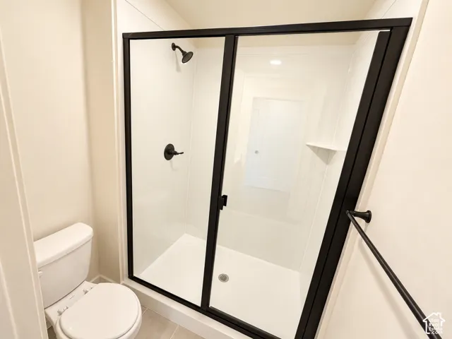 Walk-in shower with clear glass enclosure and matte black frame