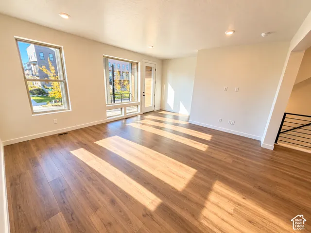Wood-finish flooring, recessed lighting, and large windows with transom panels