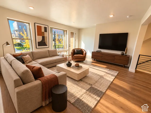Recessed lighting, wood-finish flooring, and a media console with integrated storage