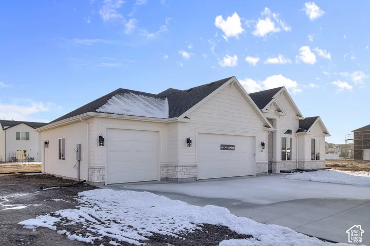 White exterior with stone accents and a dark shingled roof