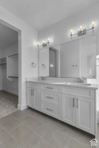 Double vanity with white cabinetry, dual sinks, and a large wall-mounted mirror