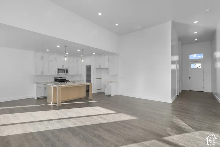 Spacious interior featuring wood-finish flooring, recessed lighting, and a kitchen island with pendant lighting