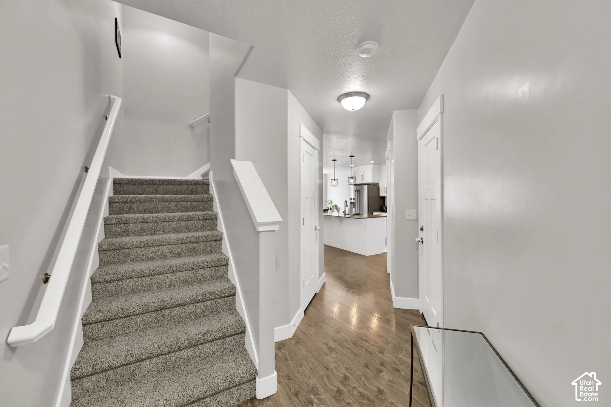 Carpeted staircase with white handrails