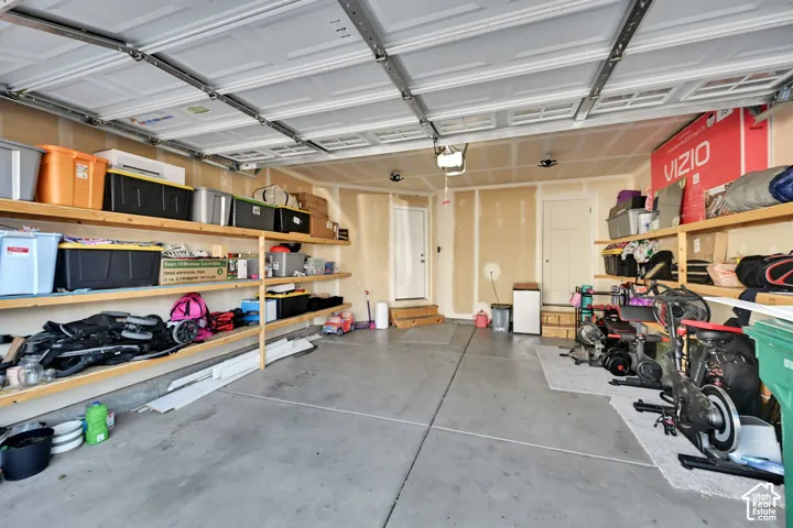 Garage featuring a concrete floor, built-in shelving, and direct access doors