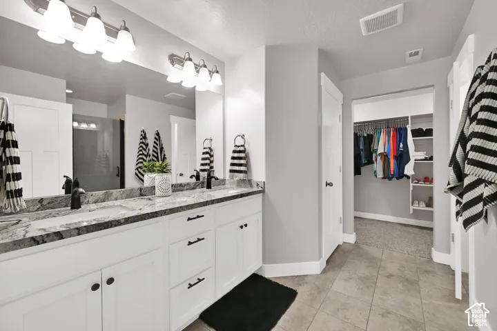 Dual vanities with undermount sinks, stone countertops, and matte black fixtures