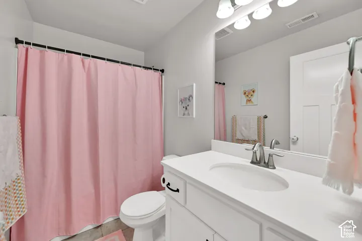 White vanity with an integrated sink and brushed nickel faucet, large vanity mirror, and overhead vanity lighting