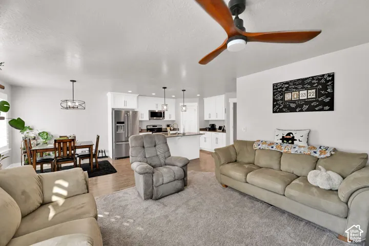 Open-concept living area featuring a modern ceiling fan, wood-finish flooring, and recessed lighting