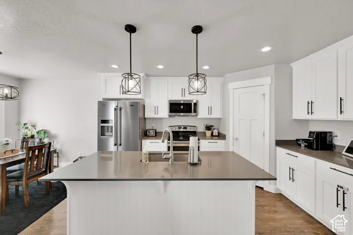 Kitchen featuring white cabinetry, stainless steel appliances, a center island with countertop, and recessed lighting