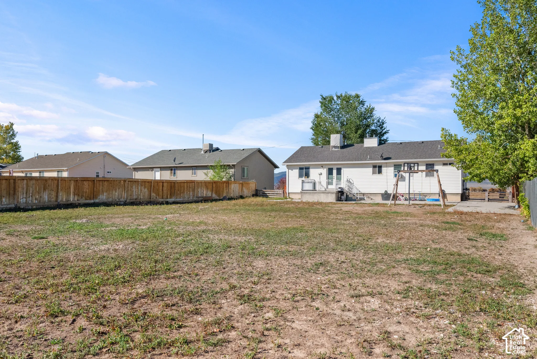 Expansive yard with wood fencing and a concrete patio