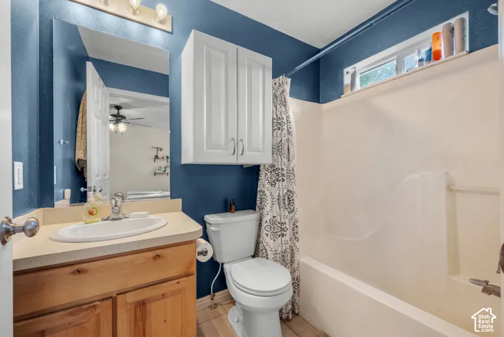 Vanity with integrated sink, wood-finish cabinetry, built-in medicine cabinet, and bathtub with overhead window