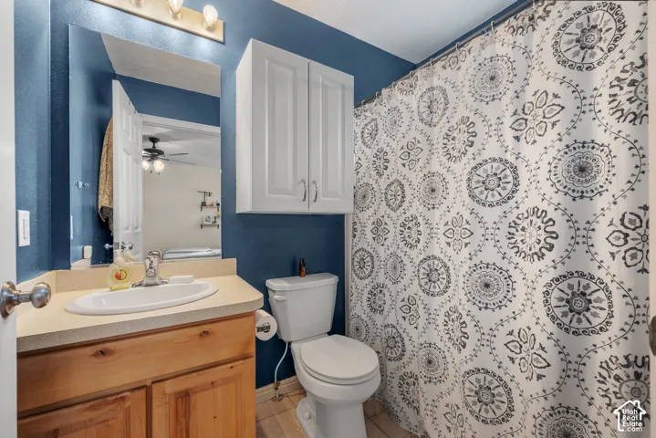 Vanity with a single basin, wood-finish cabinetry, built-in mirror, and overhead lighting