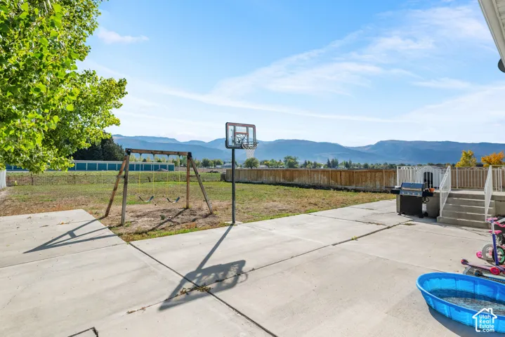 Expansive concrete patio with mountain scenery, fenced perimeter, and dedicated space for outdoor activities