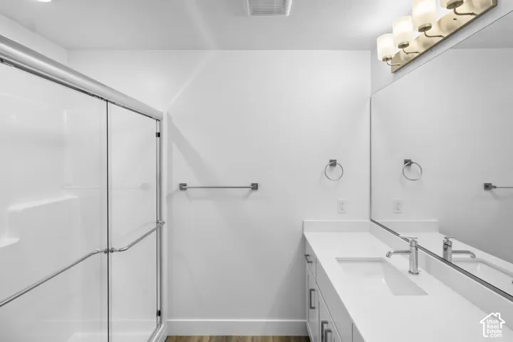 White vanity with an integrated rectangular sink, chrome-finish faucet, and a large wall-mounted mirror