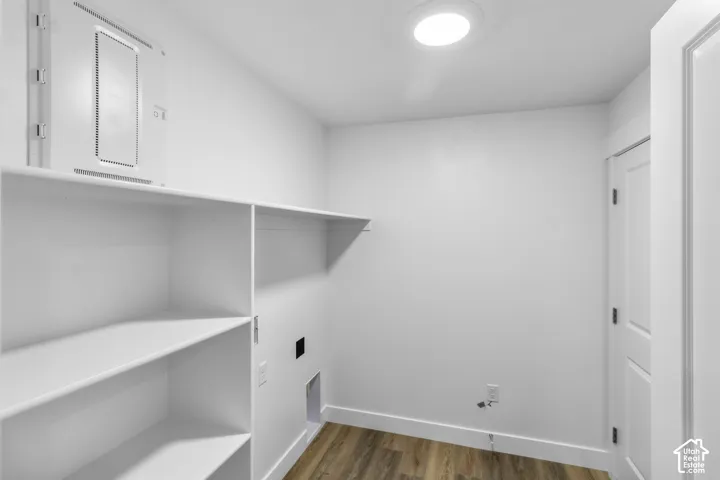 Dedicated utility space featuring built-in shelving, wood-finish flooring, and a flush-mounted ceiling light