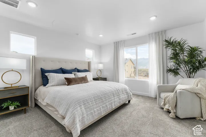 Plush carpeting, recessed lighting, and a window with mountain scenery