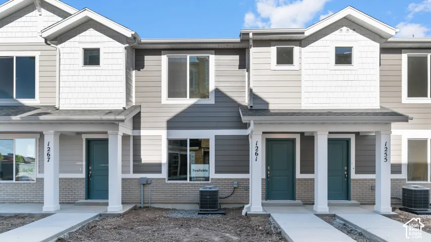 Multi-level exterior featuring light gray siding, white shake accents, and a light-colored brick foundation