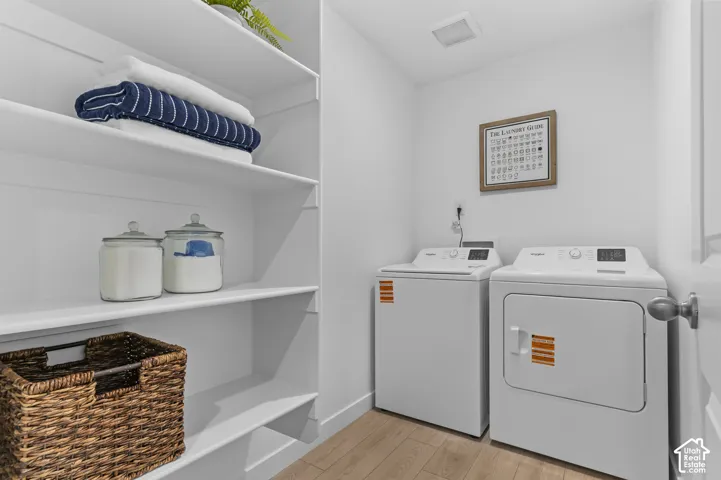White built-in shelving, durable wood-finish flooring, recessed ceiling light, and a white door with a round silver-tone knob