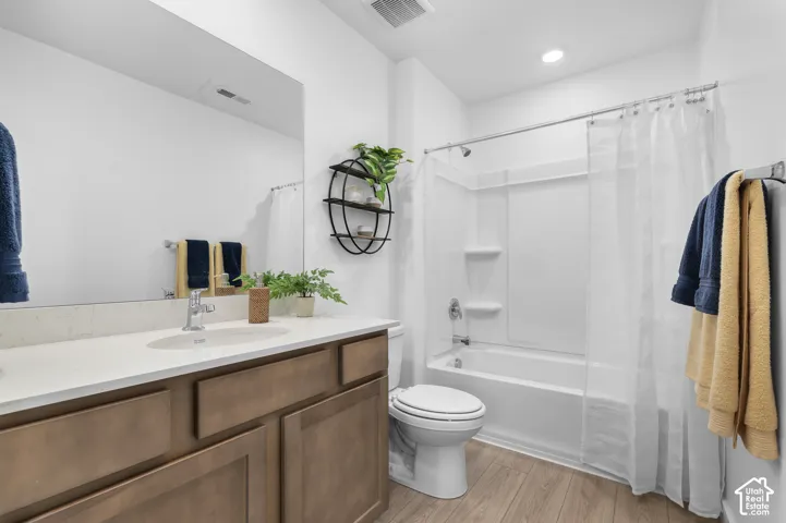 White vanity with a single basin sink and a light-colored countertop