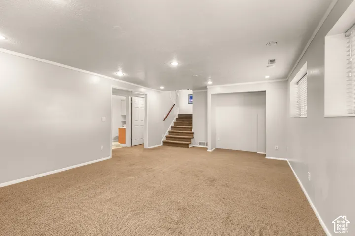 Spacious interior featuring neutral carpeting, recessed lighting, and white trim