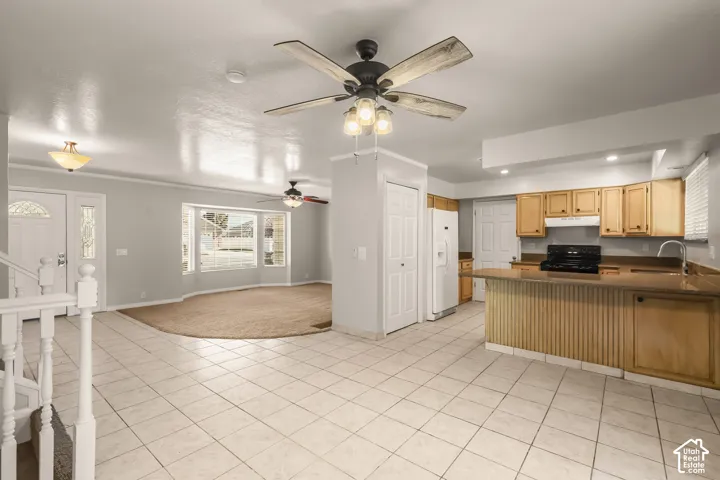 Kitchen with wood-finish cabinetry, integrated appliances, and a breakfast bar