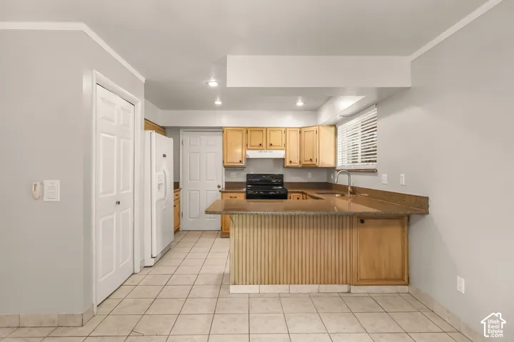 Kitchen featuring light wood cabinetry, stone countertops, stainless steel sink, and tile flooring