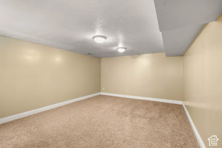 Recessed lighting, neutral-toned walls, and carpeted flooring