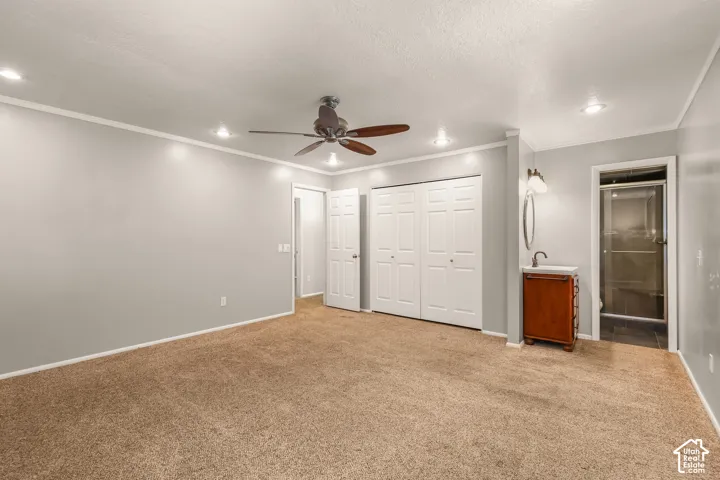 Recessed lighting, ceiling fan, white bi-fold closet doors, vanity with a rectangular sink, and an enclosed shower