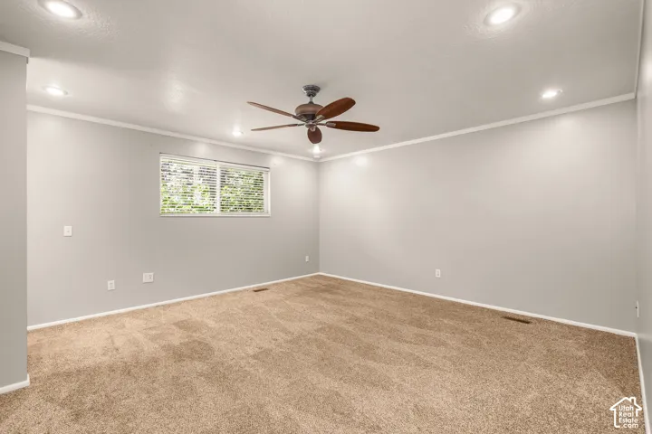 Recessed ceiling lighting, crown molding, ceiling fan, and carpeted flooring