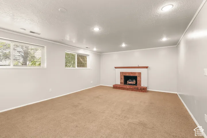 Fireplace featuring a brick surround and wood mantle